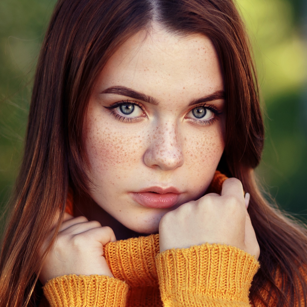 Красивая девушка в теплом свитере с веснушками на лице