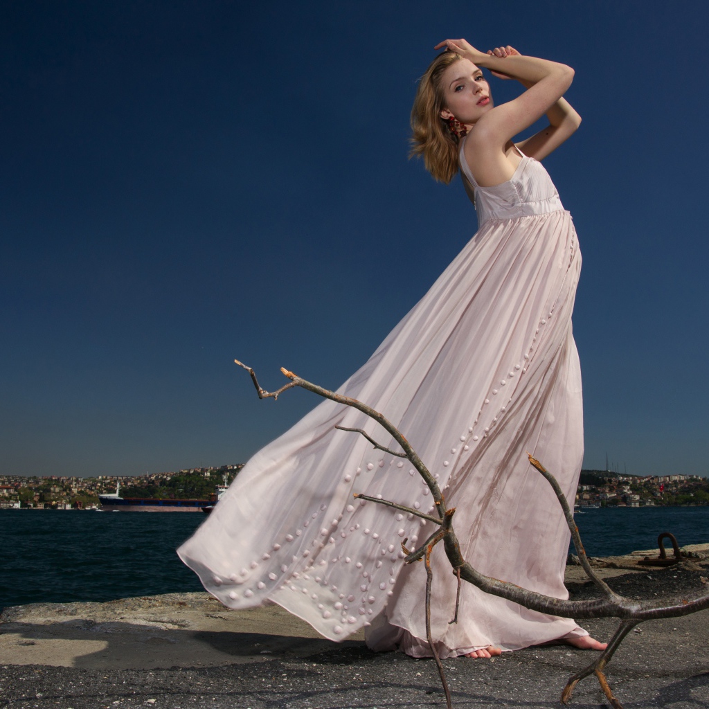 Красивая девушка в белом платье на берегу реки