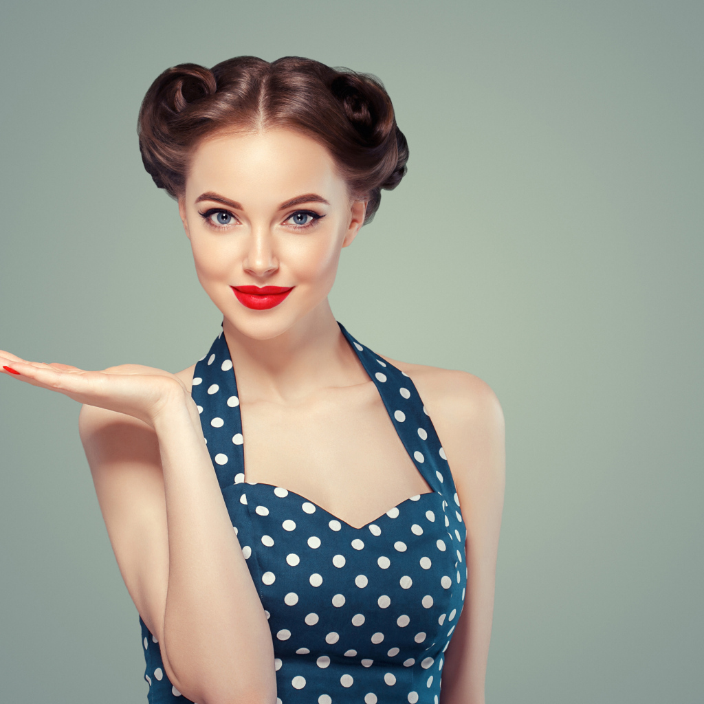 Красивая девушка в платье в горошек на сером фоне