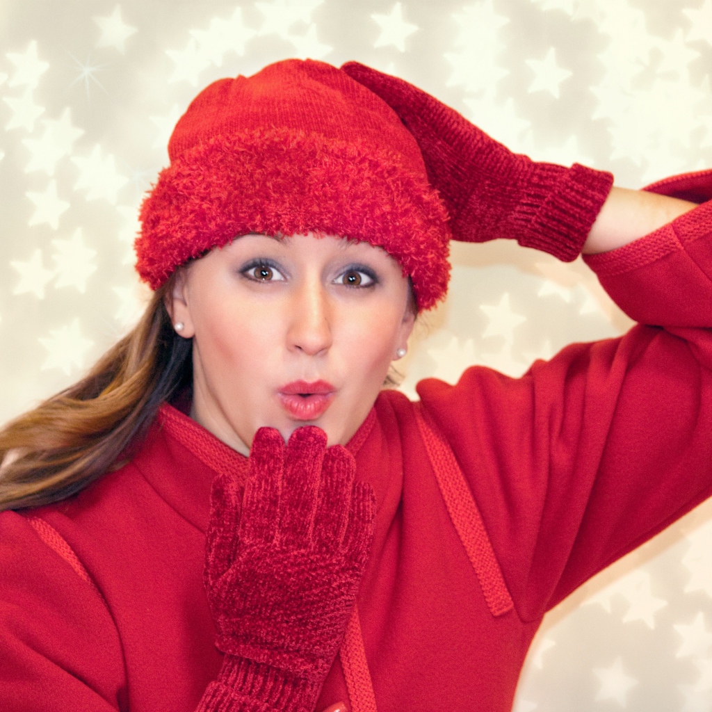 Красивая девушка в красном шлет воздушный поцелуй