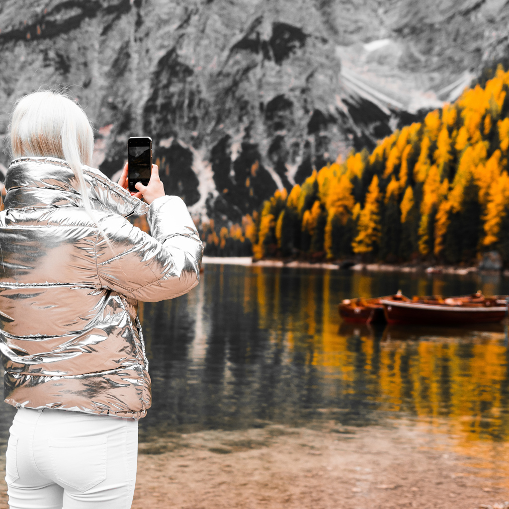 Красивая девушка делает фото гор на телефон 