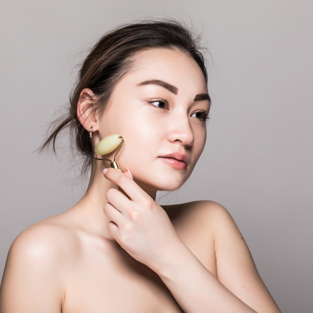 Красивая девушка разглаживает кожу лица