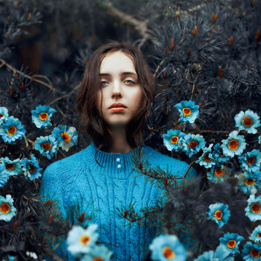 Красивая девушка колючих зарослях с голубыми цветами