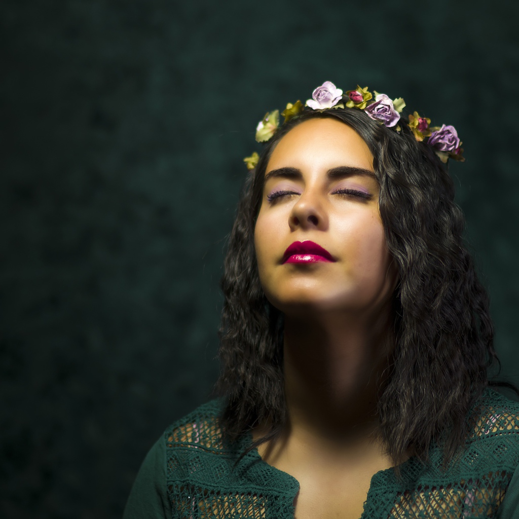 Красивая девушка с закрытыми глазами с венком на голове 