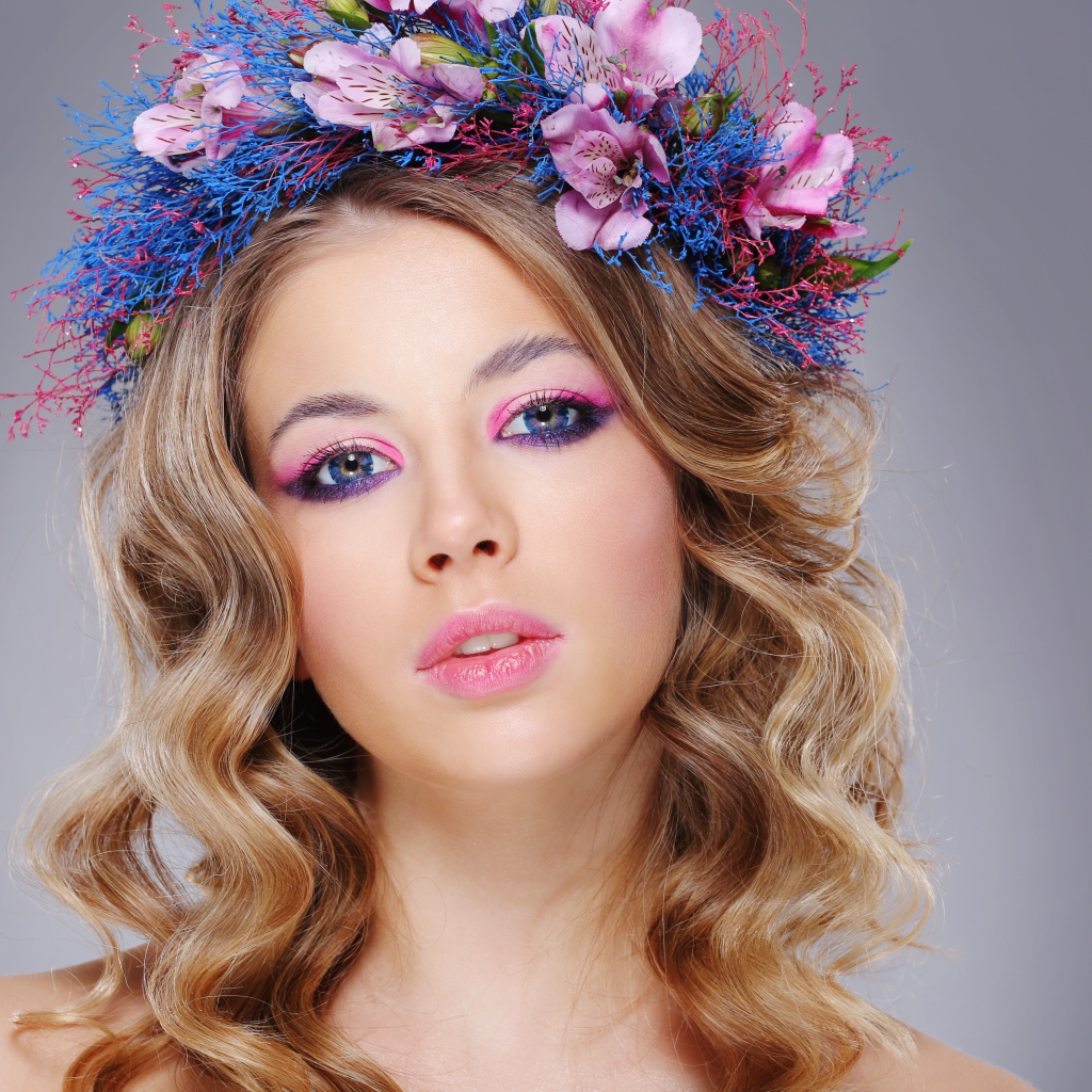 Красивая девушка с нежным макияжем с венком на голове на сером фоне