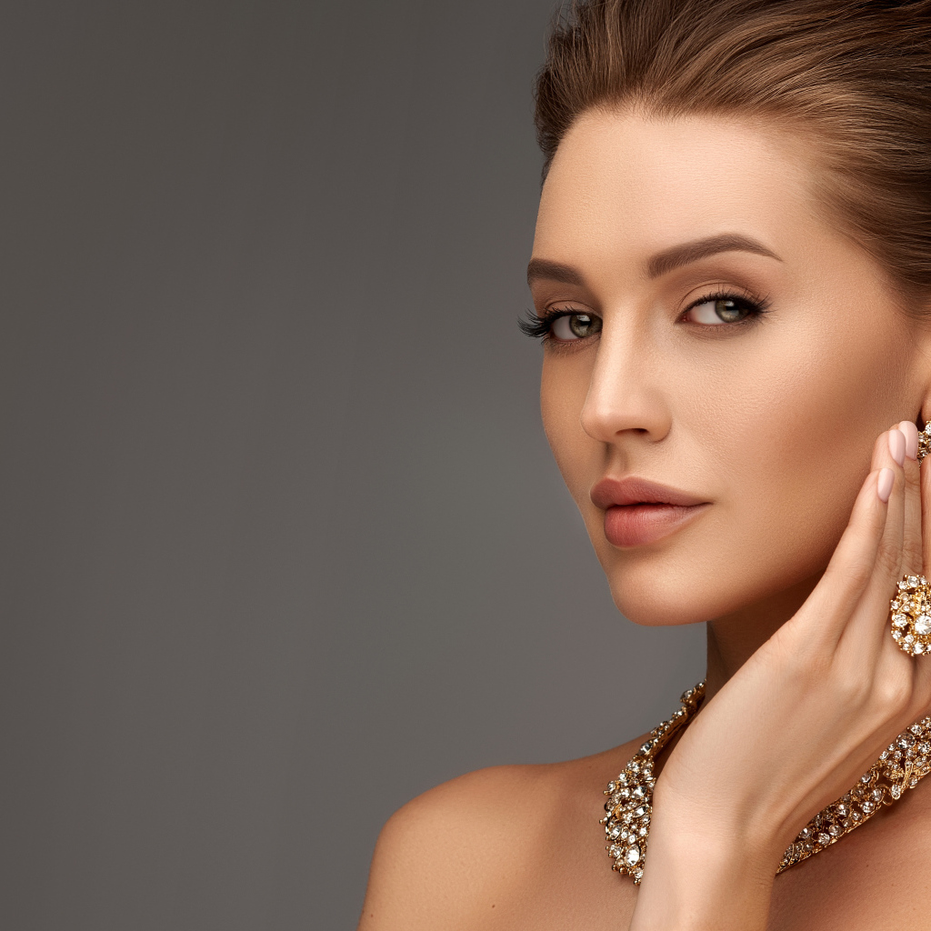 Красивая девушка с вечерней прической и дорогими украшениями