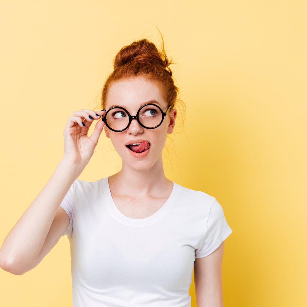 Красивая девушка в очках на желтом фоне 