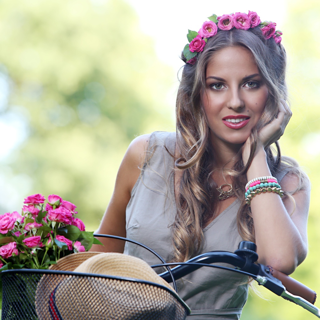 Красивая девушка с розами на велосипеде  с венком на голове