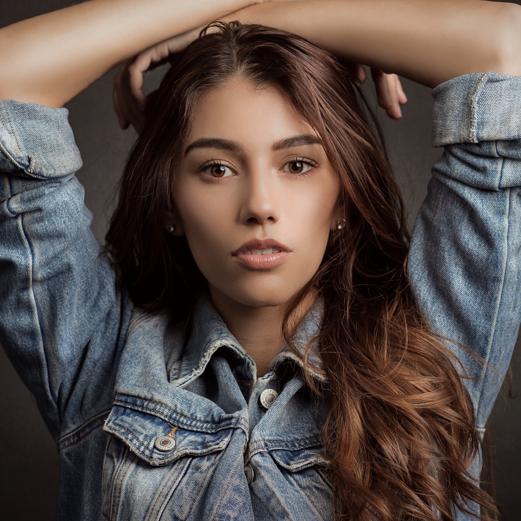 Красивая длинноволосая шатенка в джинсовой куртке 