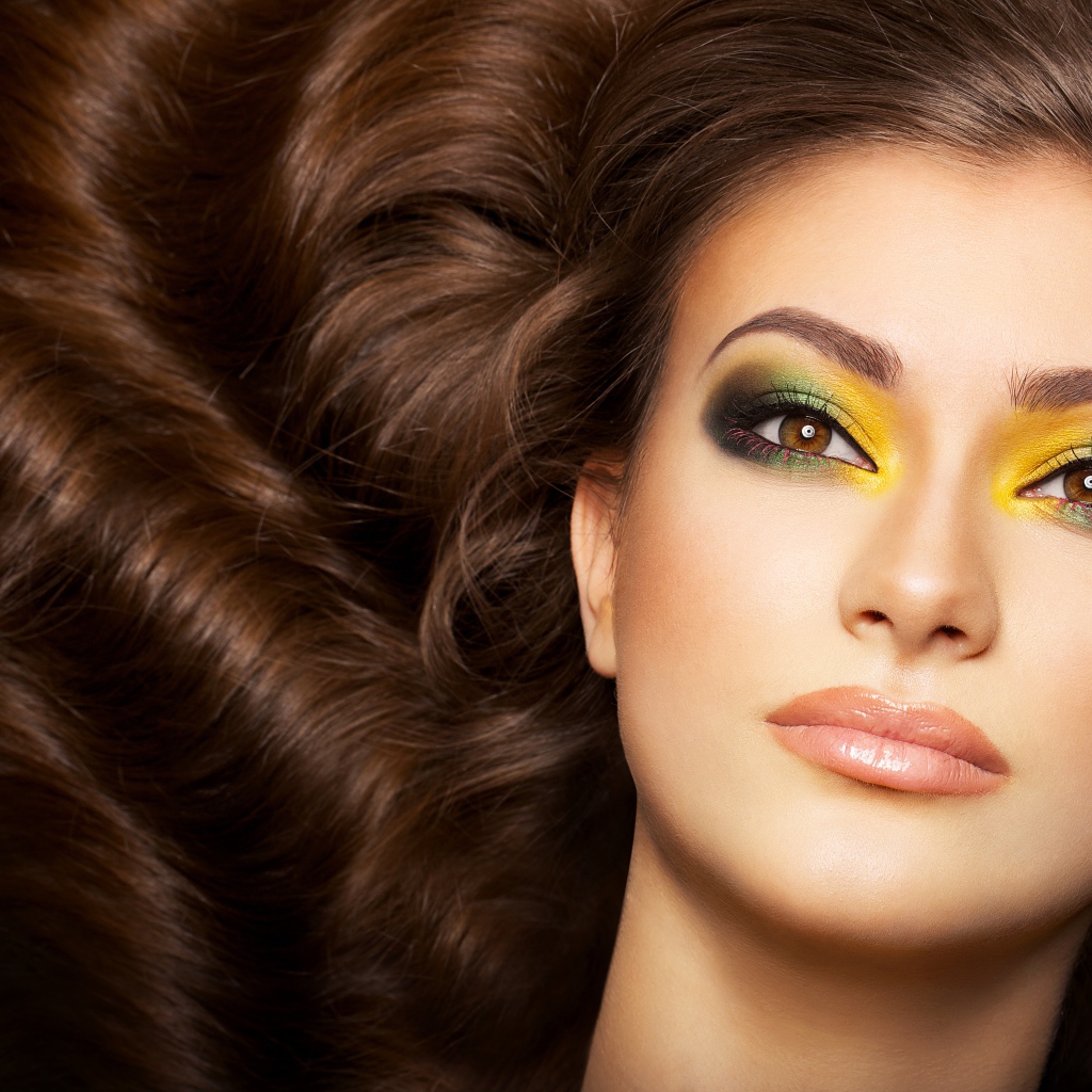 Красивая длинноволосая девушка с ярким макияжем на глазах 