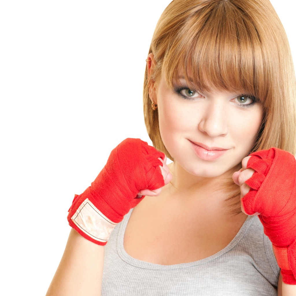 Красивая рыжеволосая девушка в стойке боксера на белом фоне