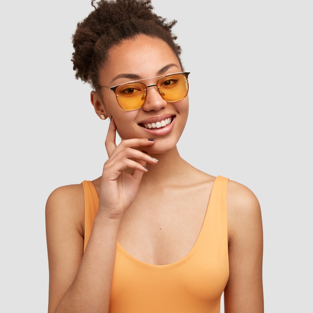 Красивая улыбающаяся темнокожая девушка в солнечных очках