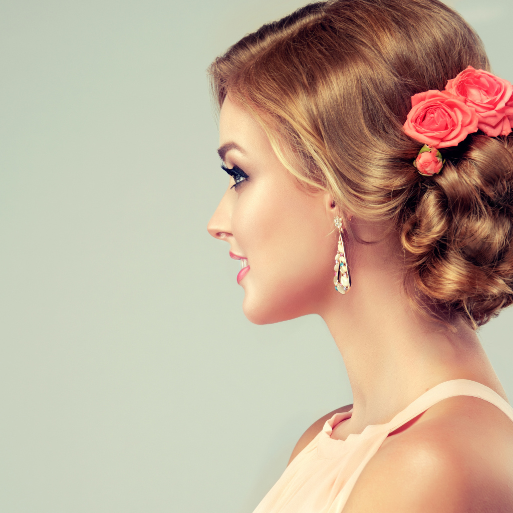 Красивая свадебная прическа у молодой девушки на сером фоне 