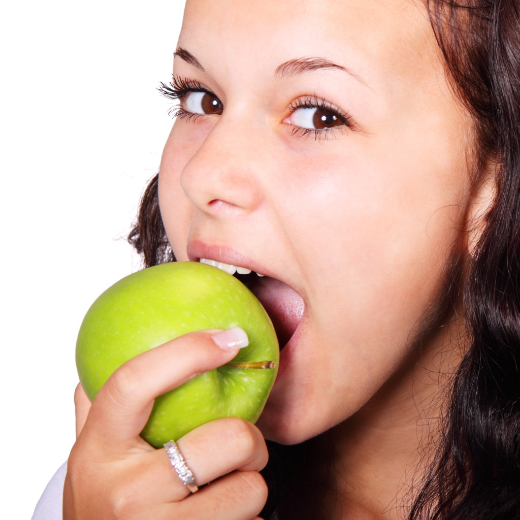 Brown-eyed girl eating a green apple