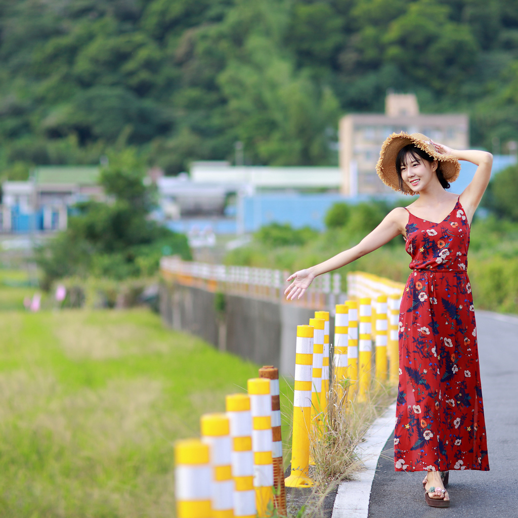 Веселая девушка азиатка в цветастом сарафане 