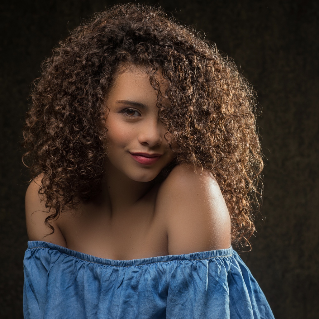 Милая кудрявая девушка в платье