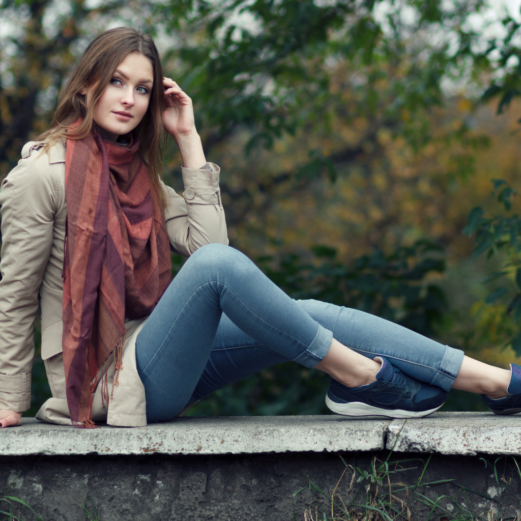 Милая девушка в куртке и синих джинсах 