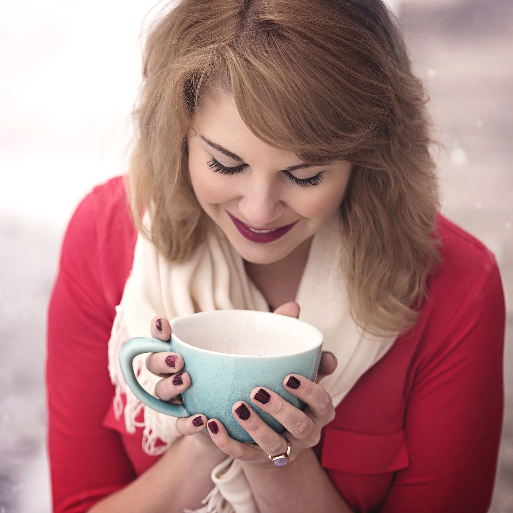 Милая девушка согревается горячим кофе