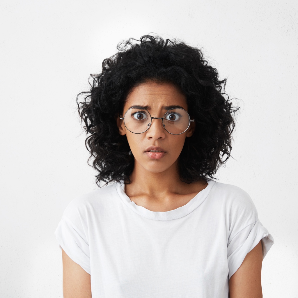 Темноволосая девушка в белой футболке на сером фоне