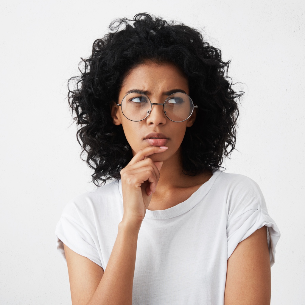 Темноволосая девушка в очках на сером фоне