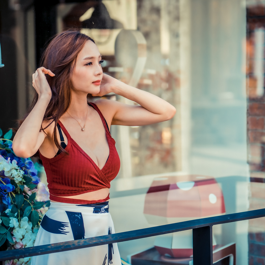 Нежная девушка азиатка стоит на балконе 