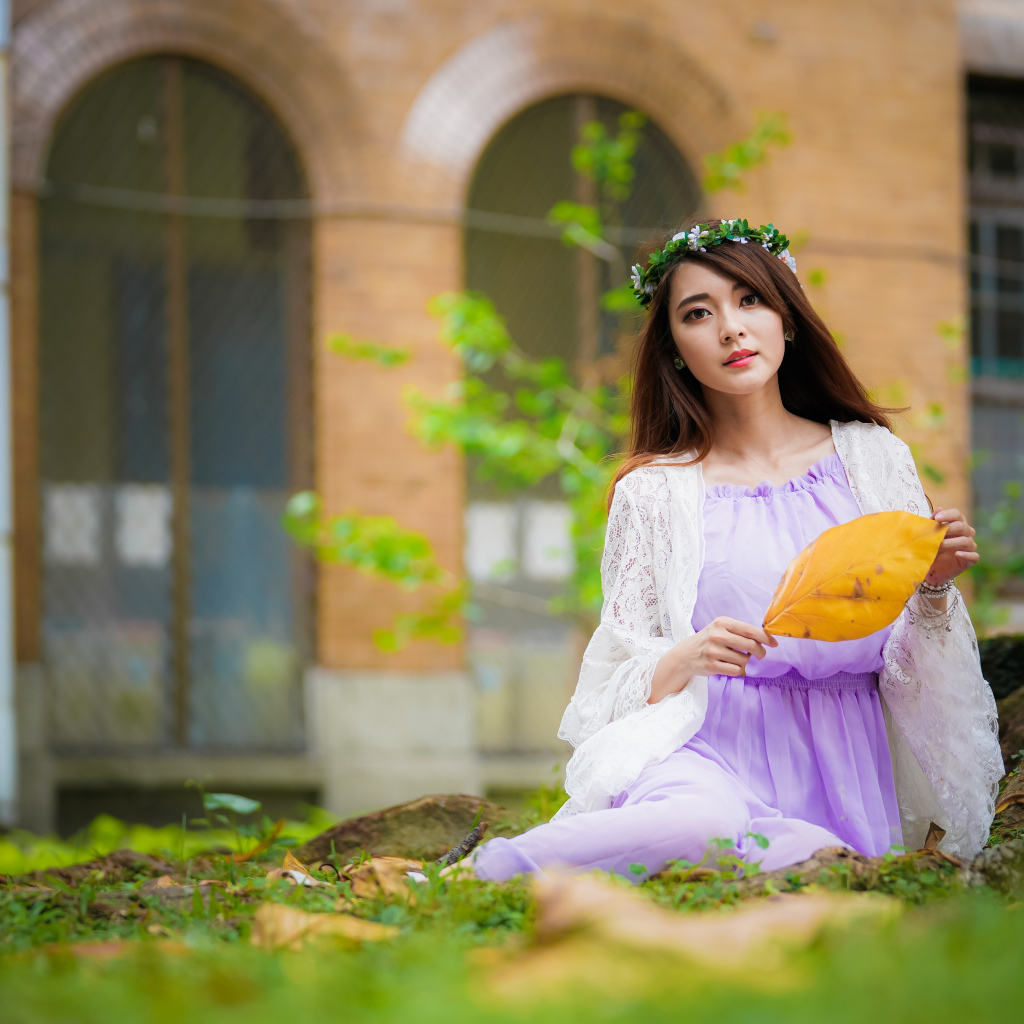 Девушка в красивом платье сидит на траве 