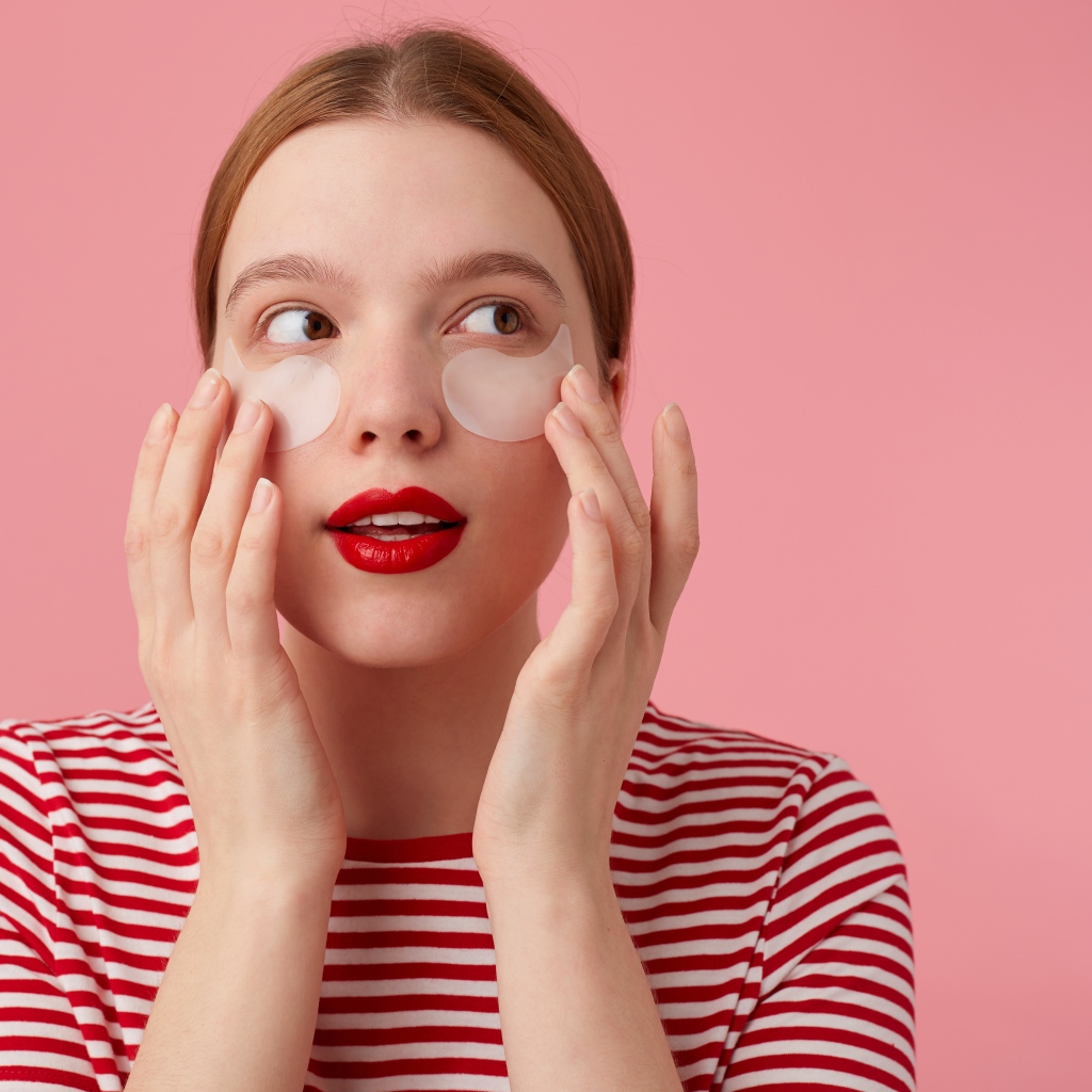 Девушка приклеивает патчи для глаз на лицо 