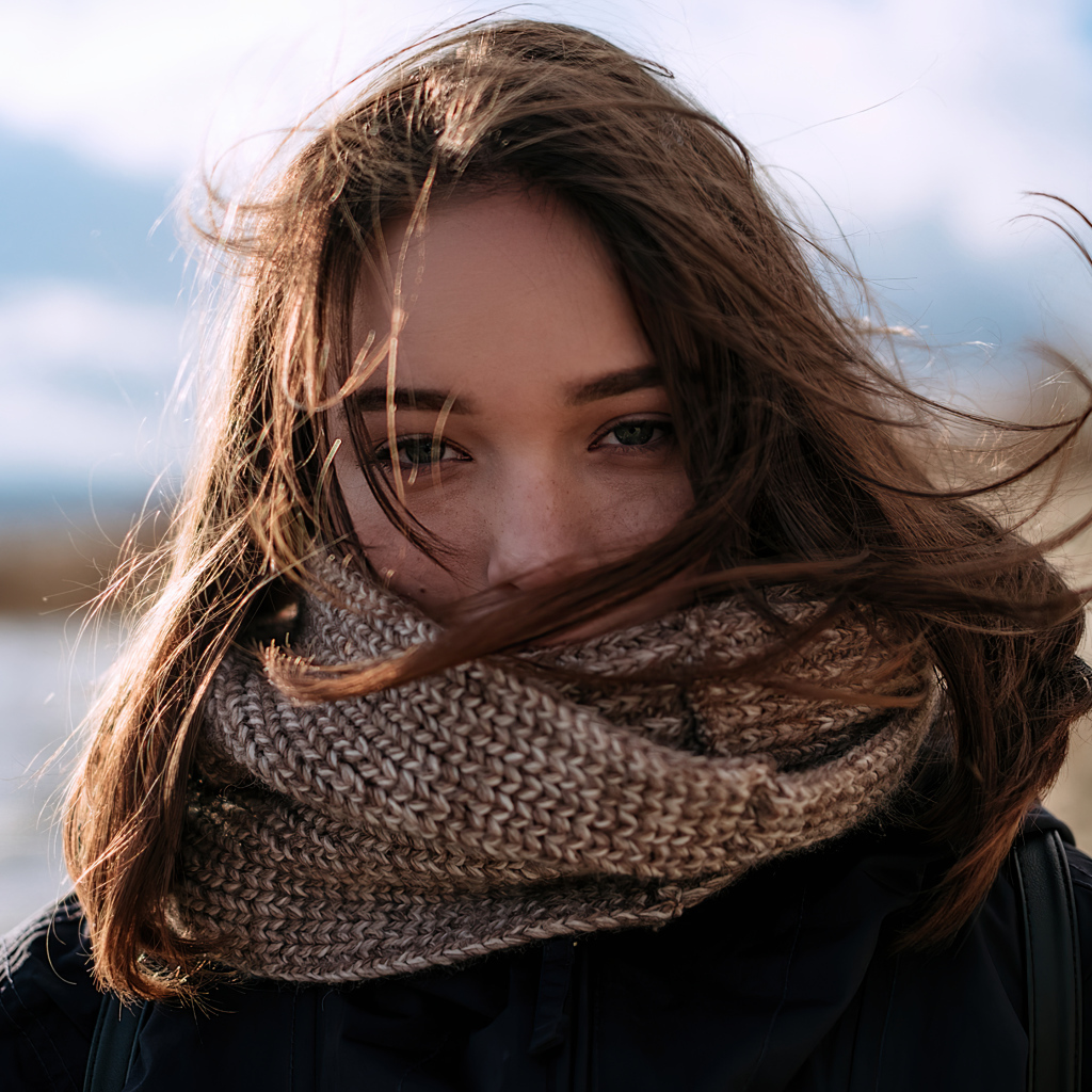 Girl with a warm knitted scarf on her face