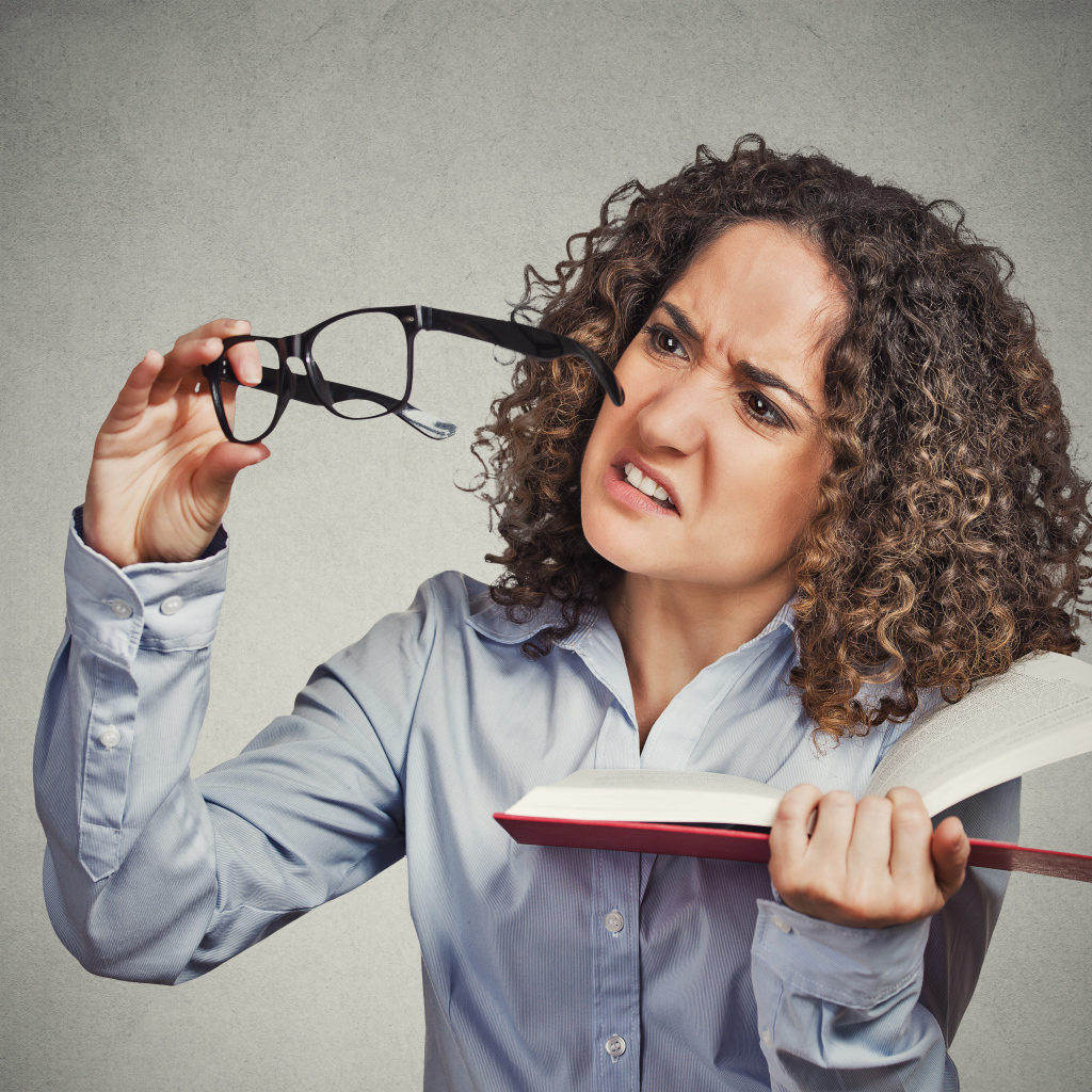 Девушка с книгой с очками в руке