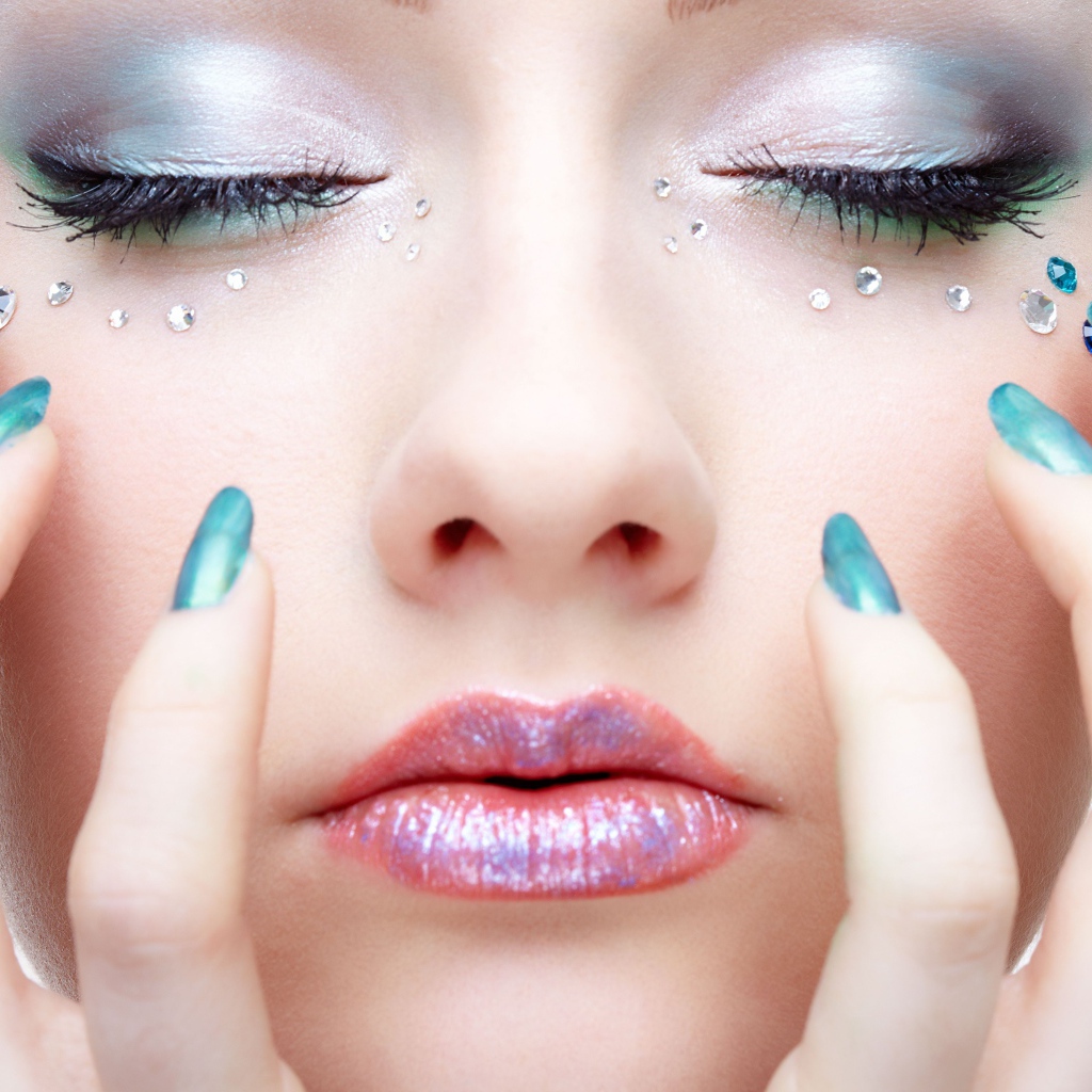 Девушка  с ярким макияжем и стразами на лице 