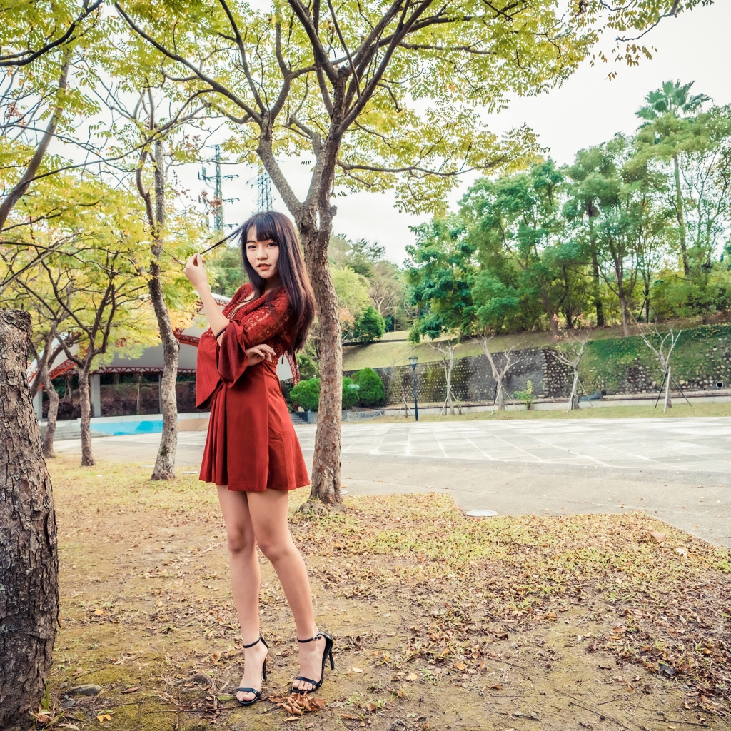 Длинноногая девушка азиатка в коротком красном платье 