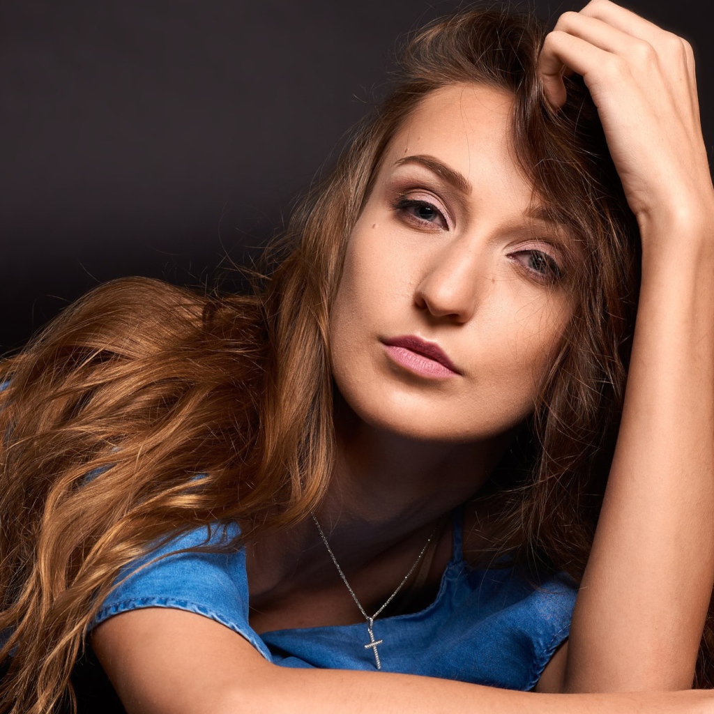 Длинноволосая шатенка лежит на полу в голубом платье 