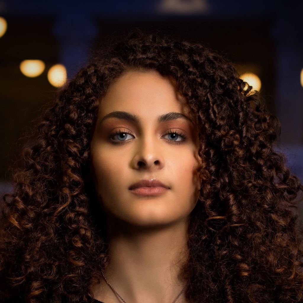 Длинные кудрявые волосы у красивой голубоглазой девушки