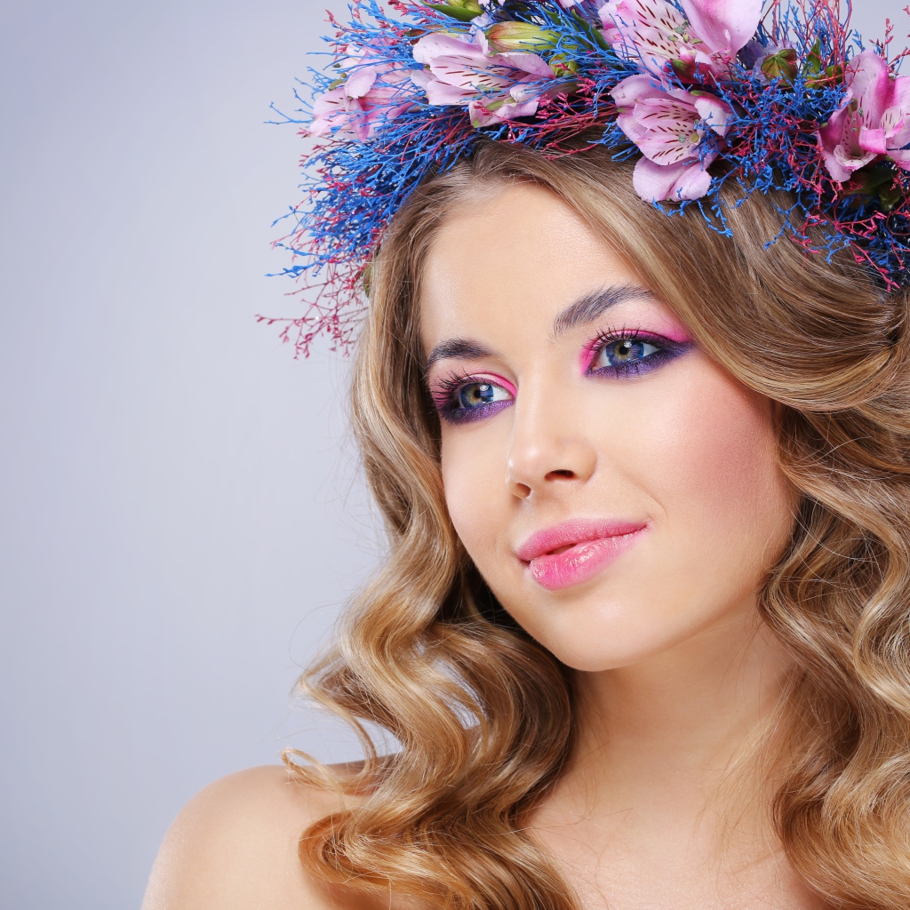 Милая девушка с венком на голове на сером фоне 