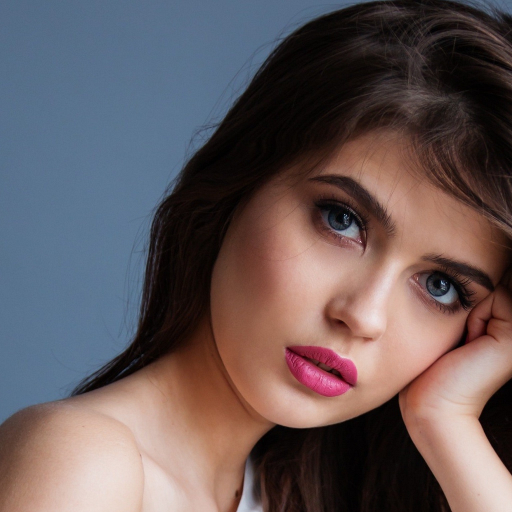 Милая девушка с розовыми губами на сером фоне
