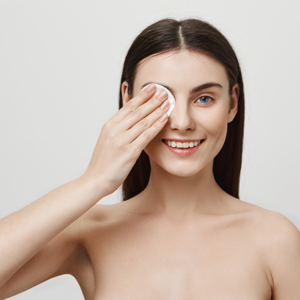 Настоящая голубоглазая девушка снимает макияж с лица