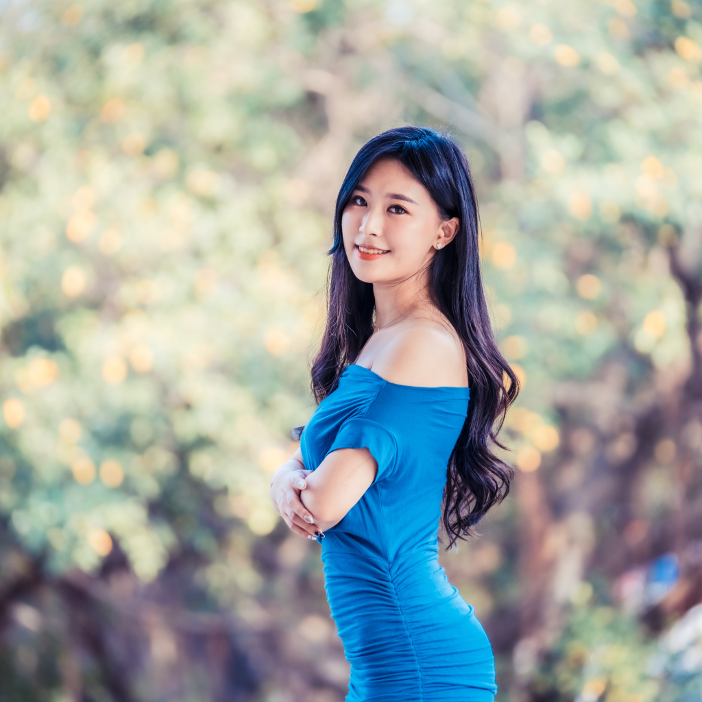 Улыбающаяся девушка азиатка в голубом платье 