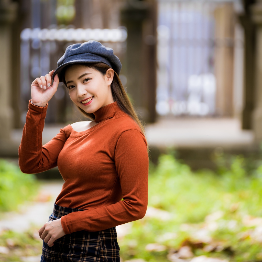 Улыбающаяся девушка азиатка в кепке 