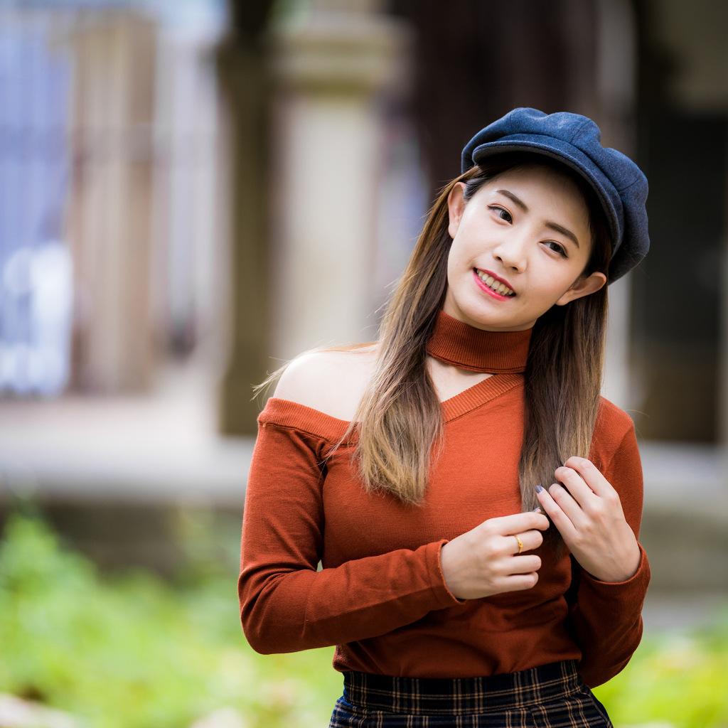 Улыбающаяся азиатка в черной кепке 