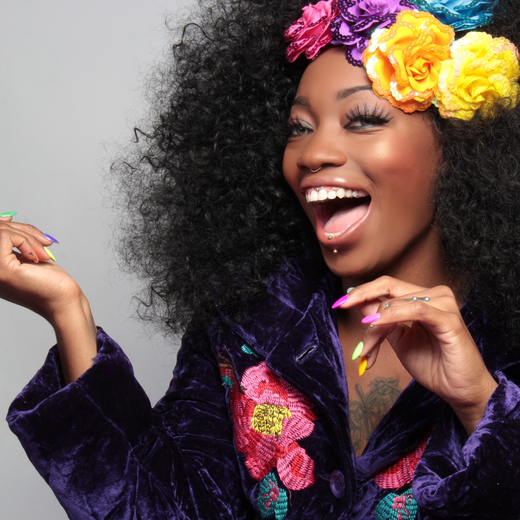 Улыбающаяся темнокожая девушка с цветами в волосах 