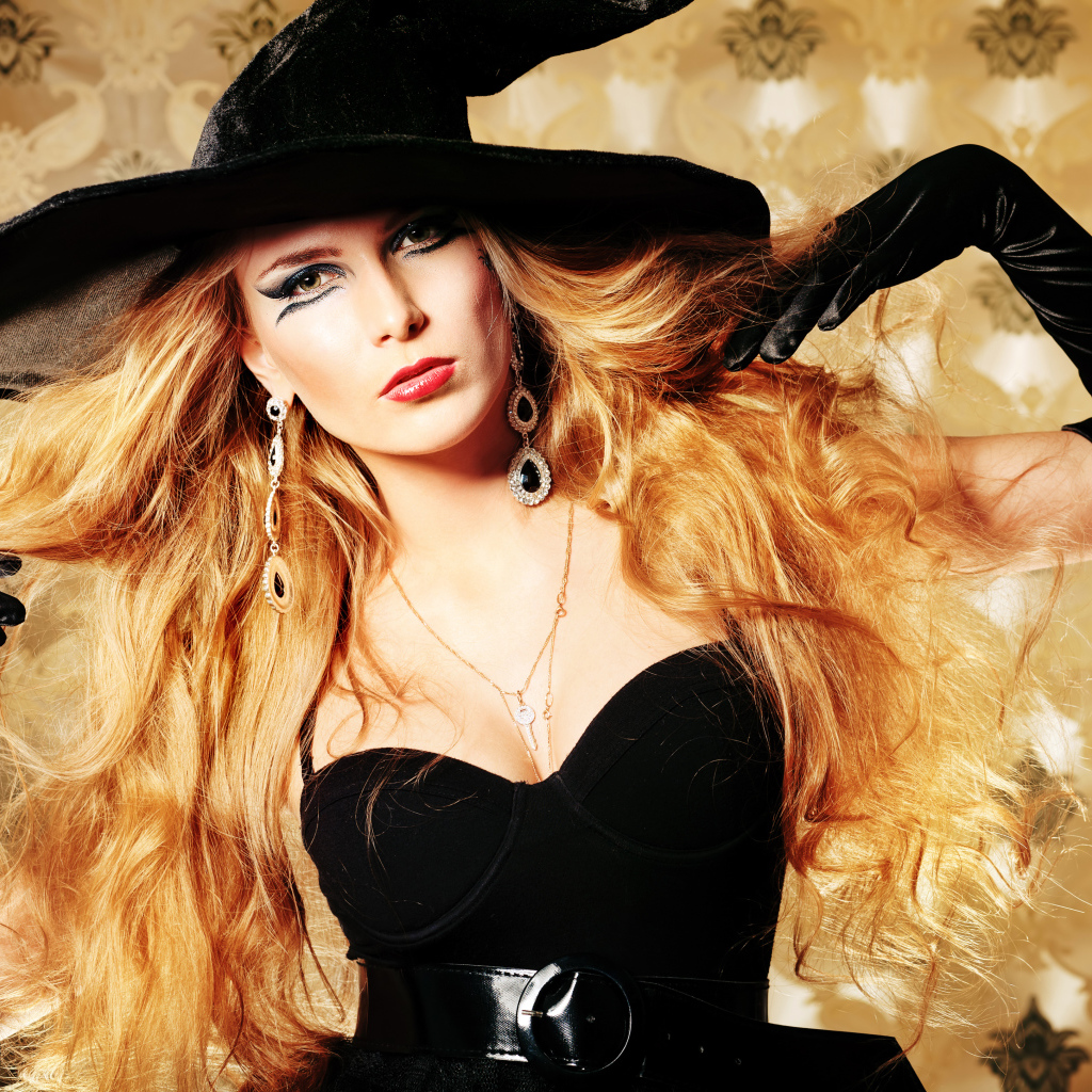 Эффектная девушка в черном костюме ведьмы на Хэллоуин