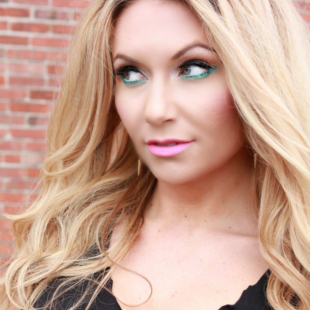 Эффектная длинноволосая блондинка у стены 