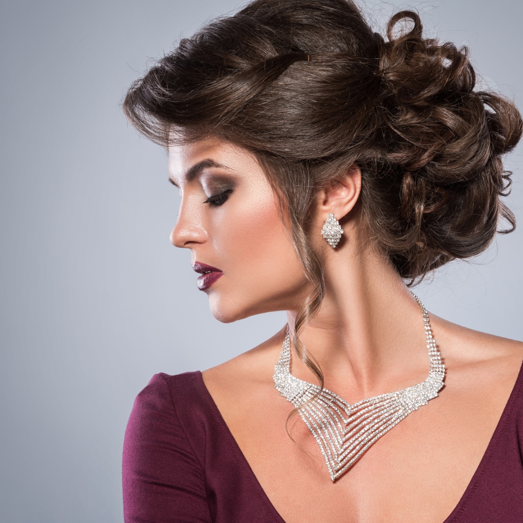 Стильная женщина с вечерней прической, макияжем и дорогими украшениями