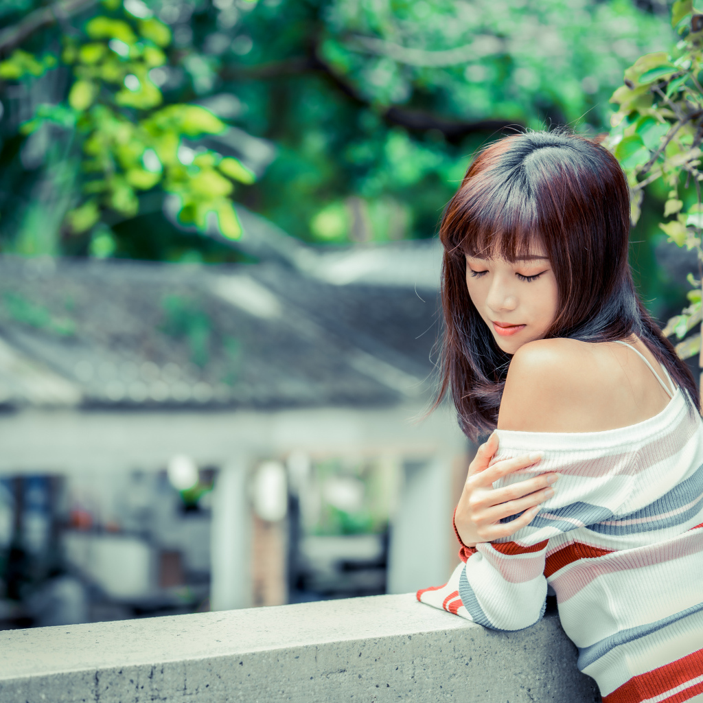 Нежная азиатка стоит на балконе