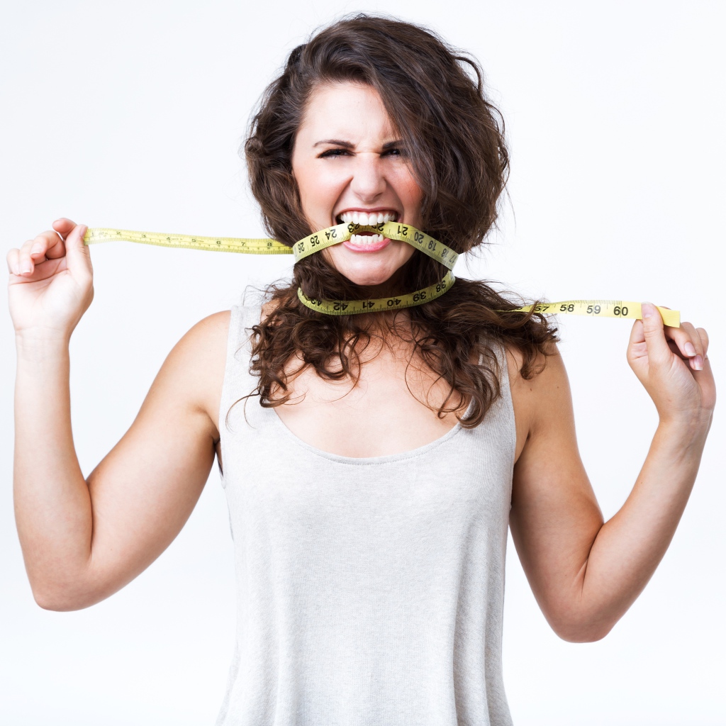 Блондинка в белой майке грызет сантиметр 