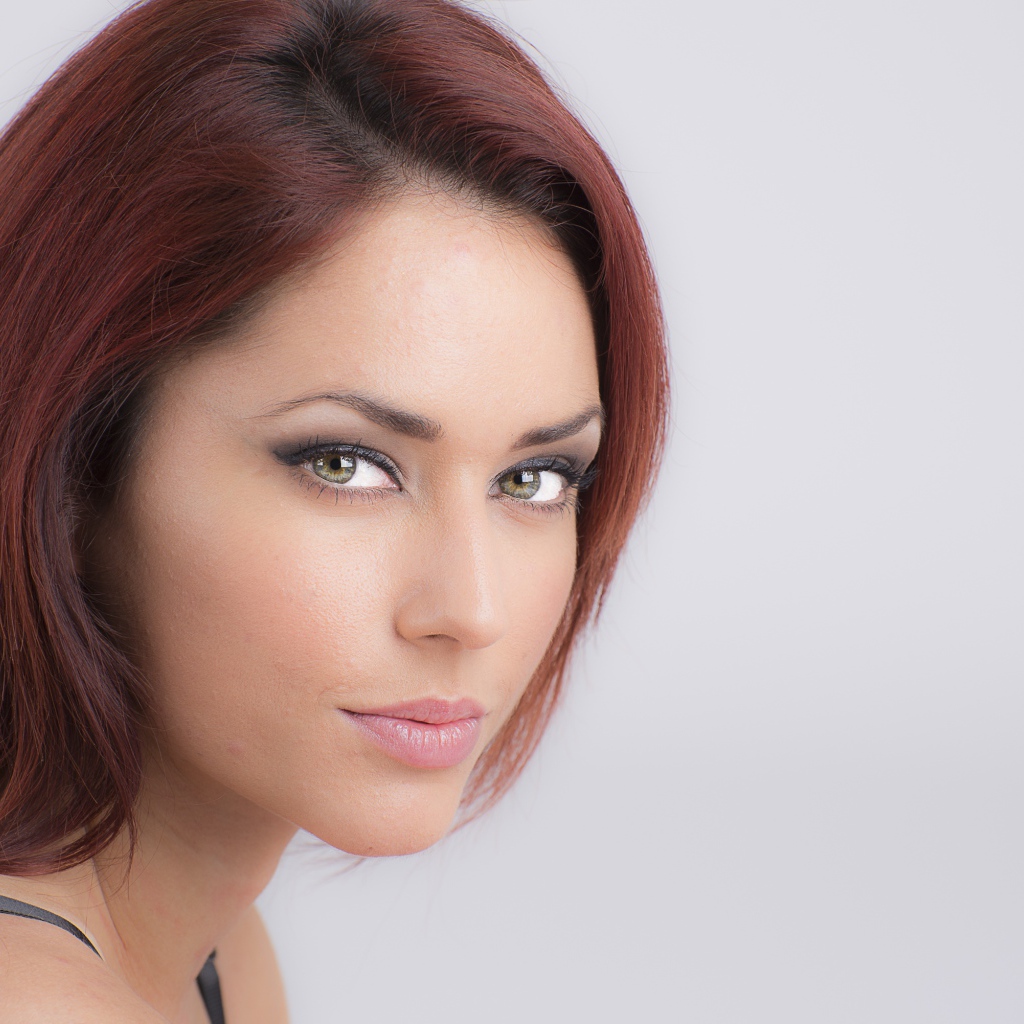 Лицо стильной девушки с зелеными глазами на сером фоне