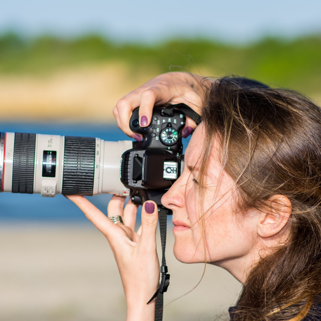 Девушкой делает фото на фотоаппарат 