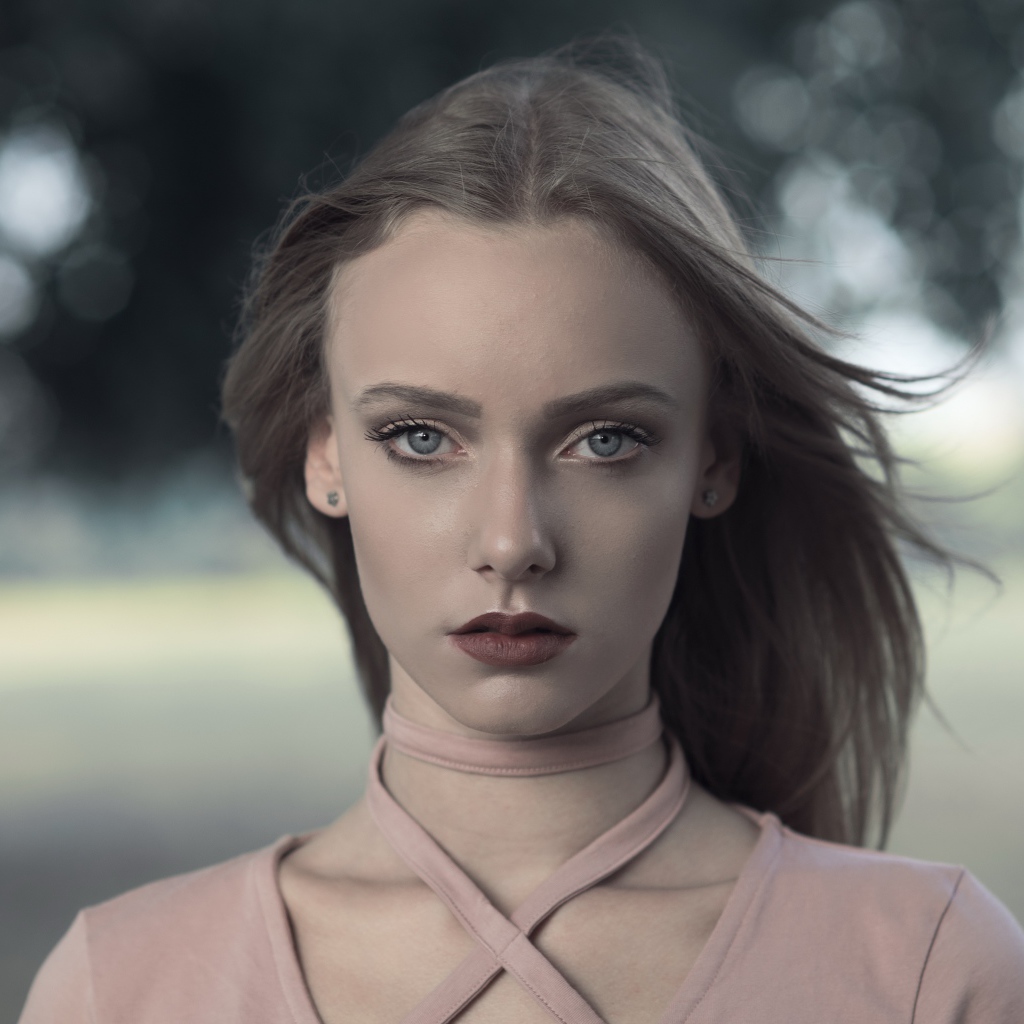 Ветер развивает волосы красивой голубоглазой девушки