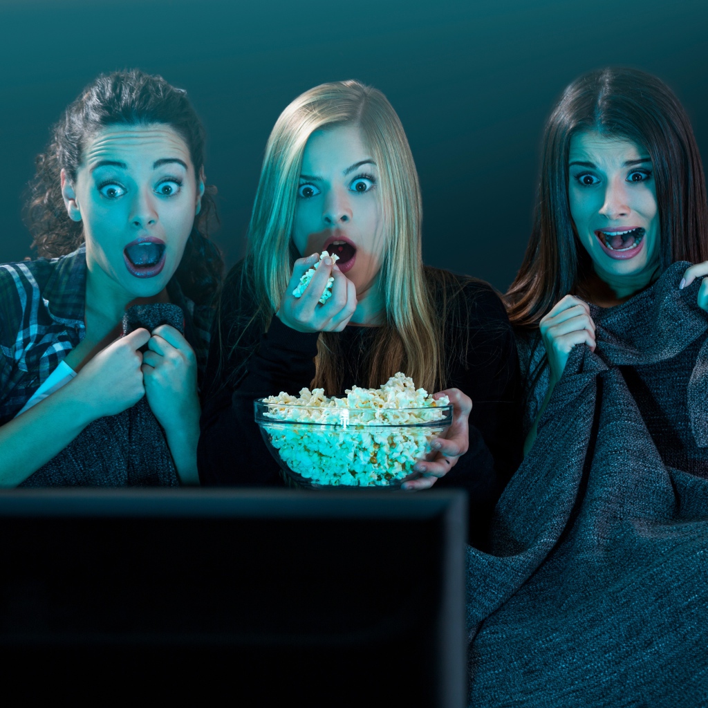 Три подруги смотрят фильм ужасов по телевизору 