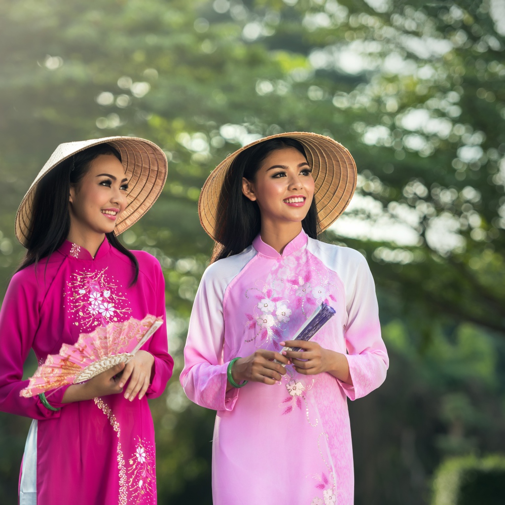 Две девушки азиатки в платьях с веером в руках